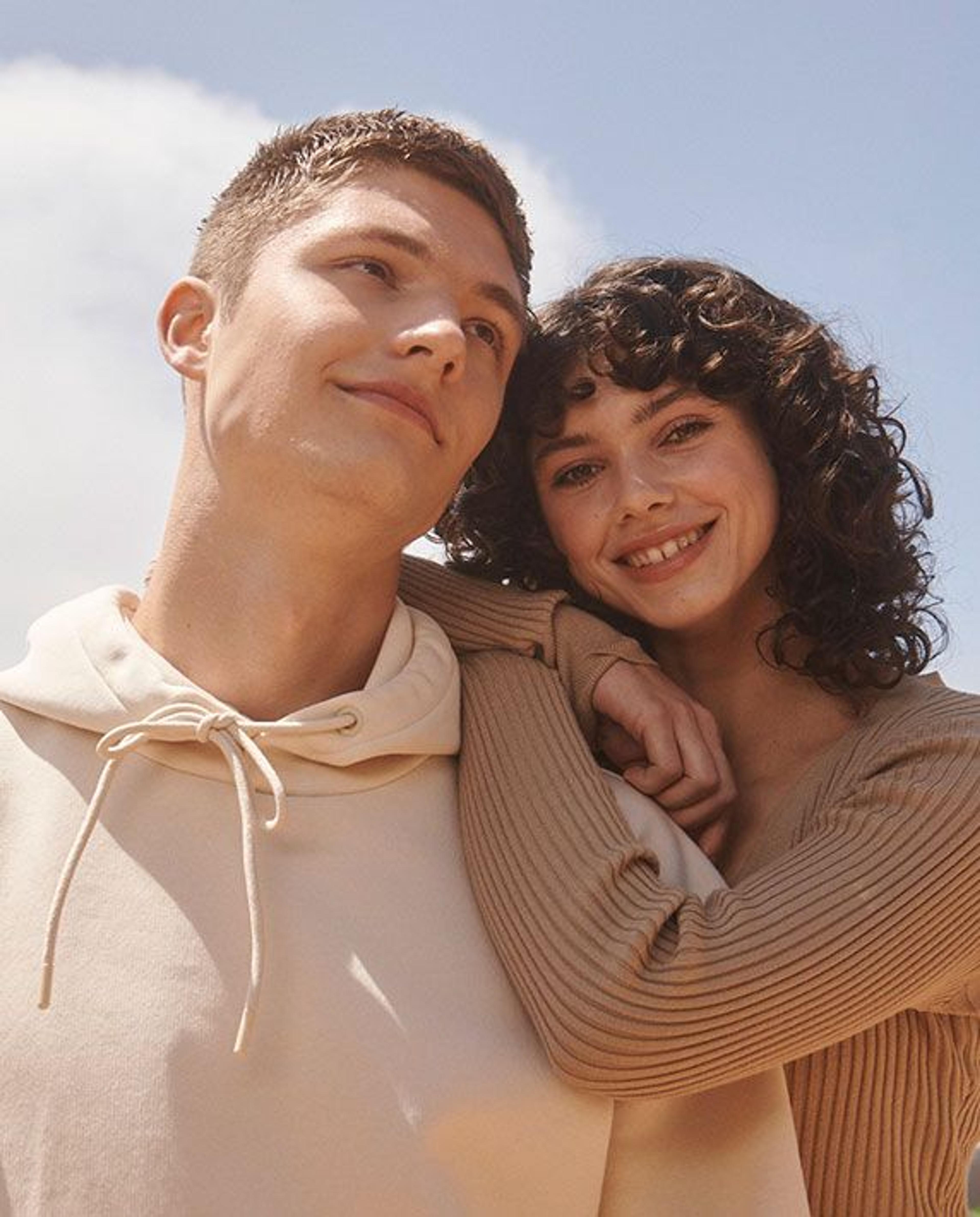 A couple smiling outside in the sunlight
